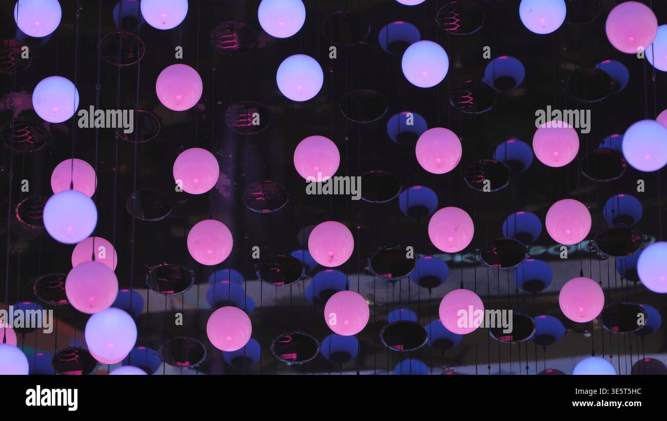 Pink glowing spheres creating a vibrant abstract light installation Stock Photo