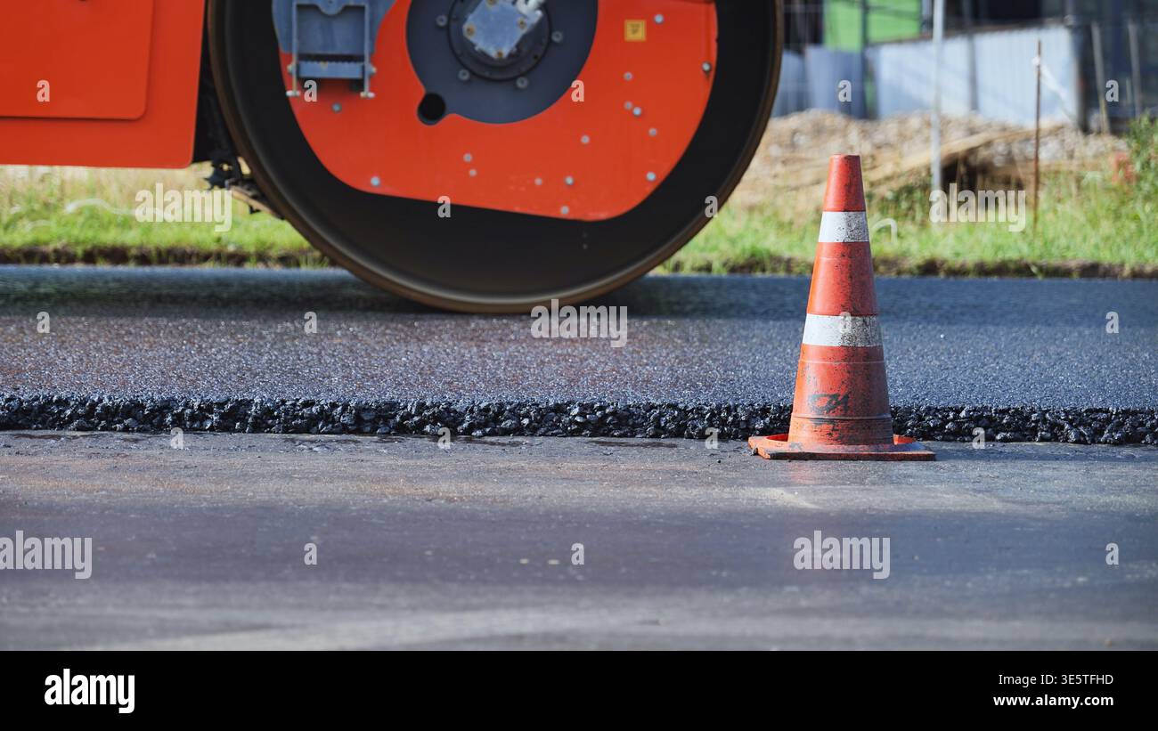 Road construction worker compacting black asphalt with heavy ...