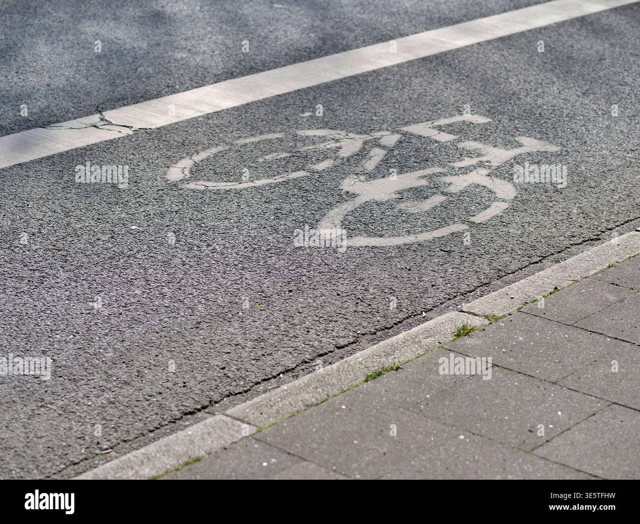 White bicycle symbol painted on asphalt road. Close up of bike lane ...