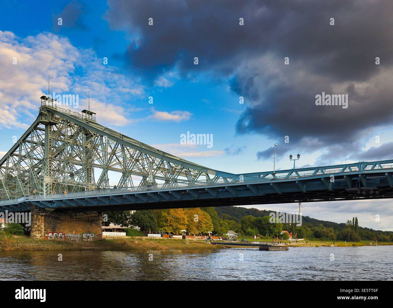 Dresden: Das Blaue Wunder aus der Froschperspektive – Beeindruckende Stahlfachwerk-Konstruktion über der Elbe bei dramatischem Himmel Stock Photo