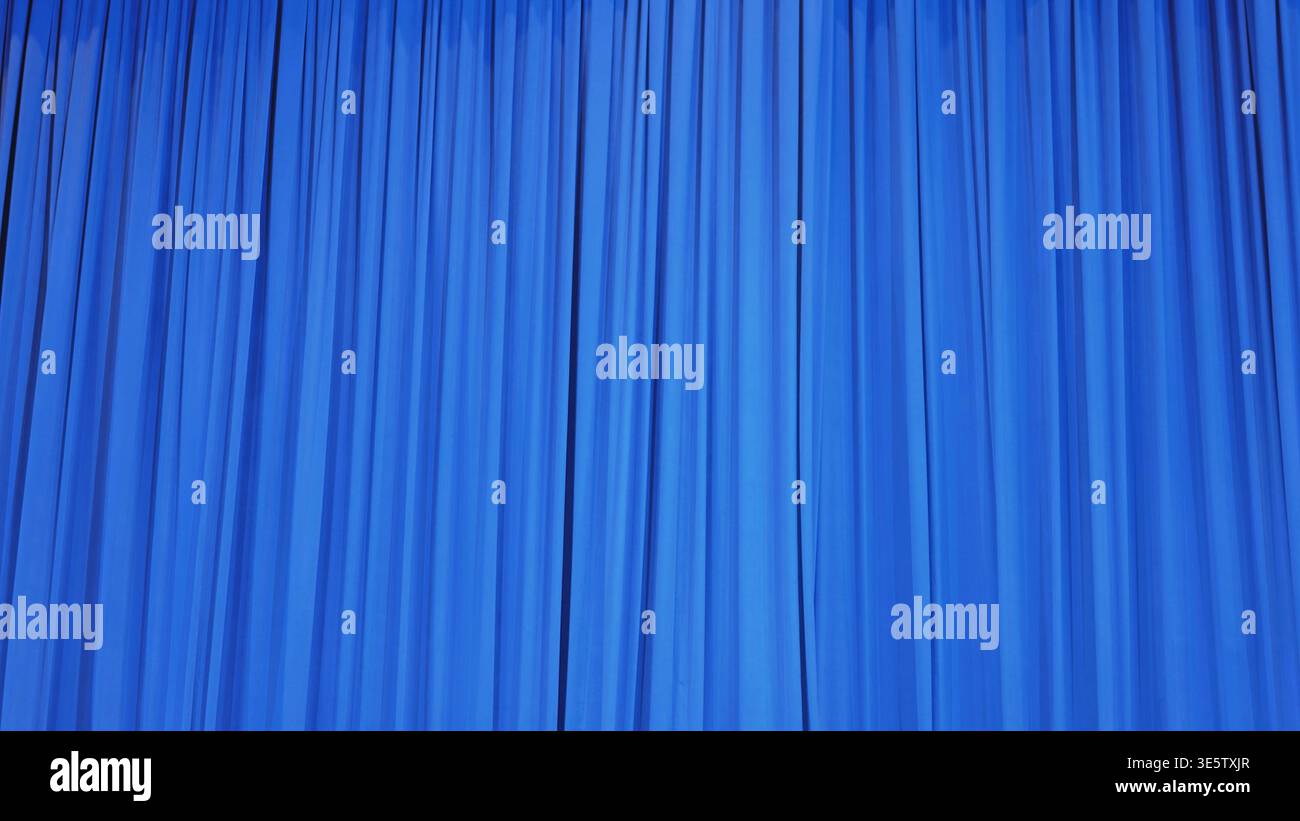 Vibrant blue curtain with dramatic vertical folds, abstract texture background for stage or display Stock Photo