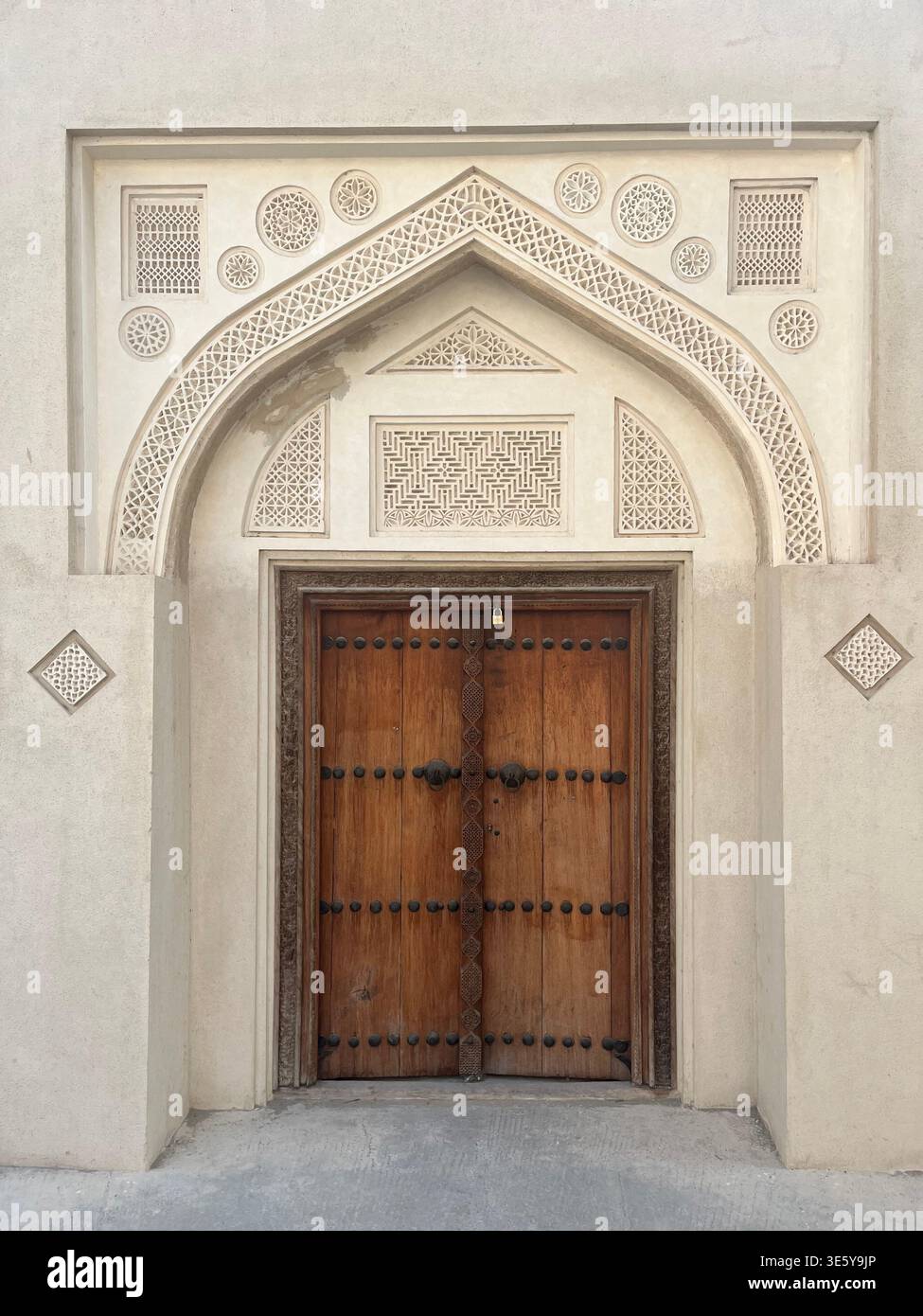 Bahrain Patterns Traditional wooden door with decorative arch and geometric patterns on ...