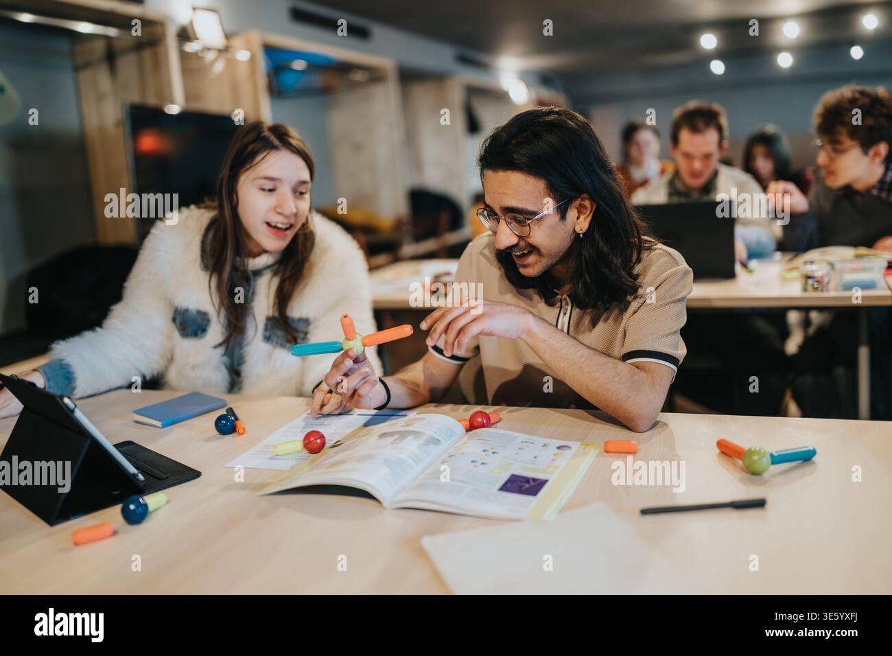 Young students collaborating on a hands-on science project in a modern classroom setting Stock Photo