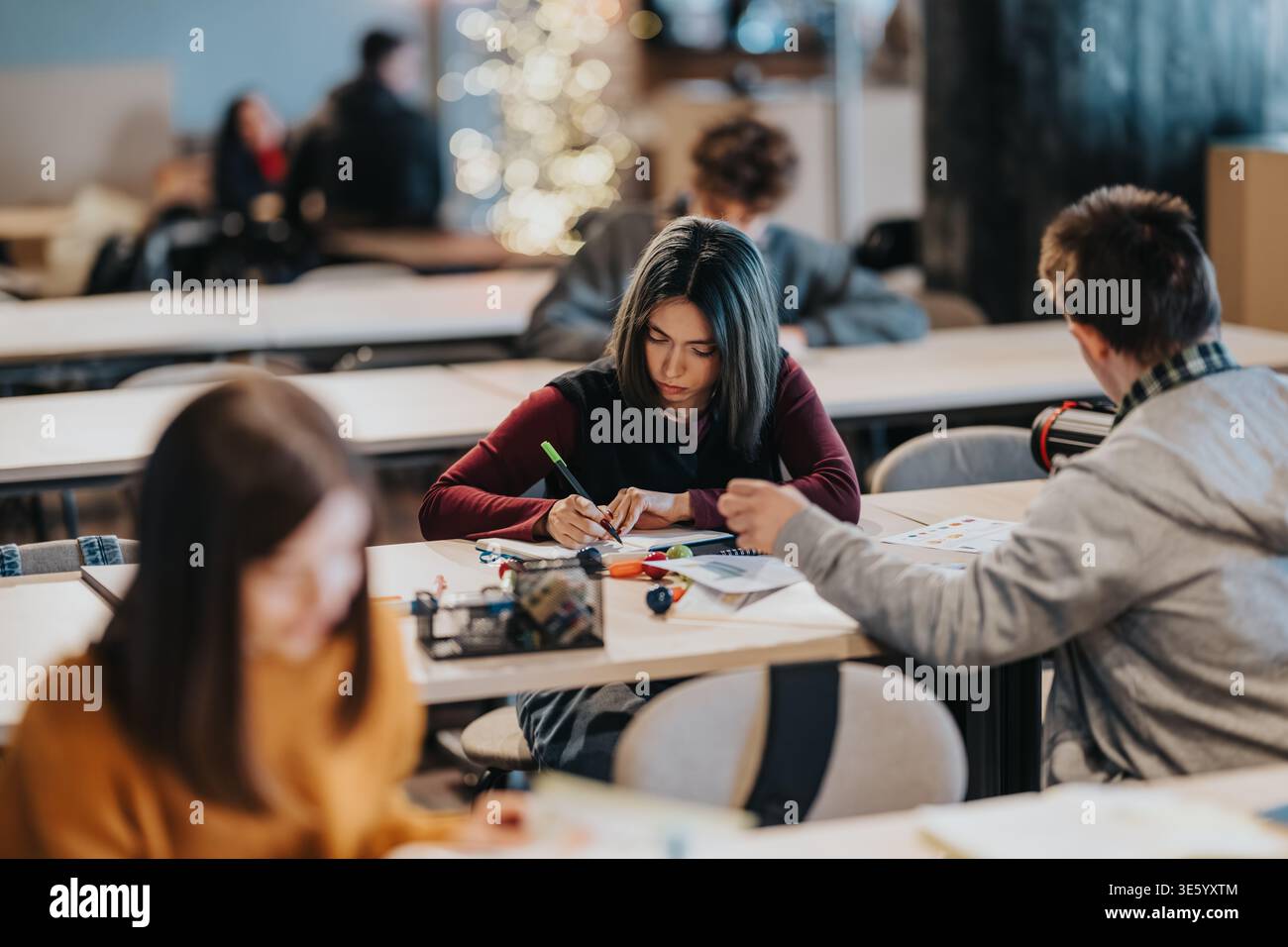 Students studying together in a modern classroom during focused group work session Stock Photo