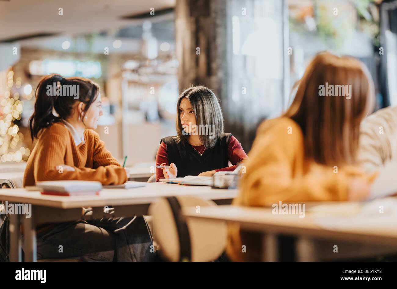Students studying together in a modern classroom discussing notes during a group study session Stock Photo