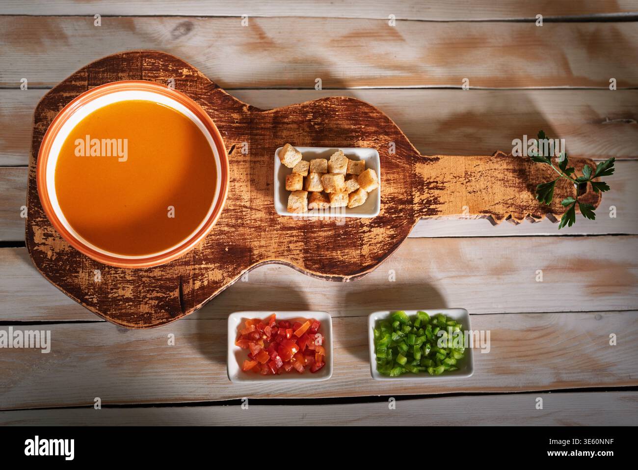 Bowl of gazpacho, along with the accompanying vegetables and toasted bread. Stock Photo