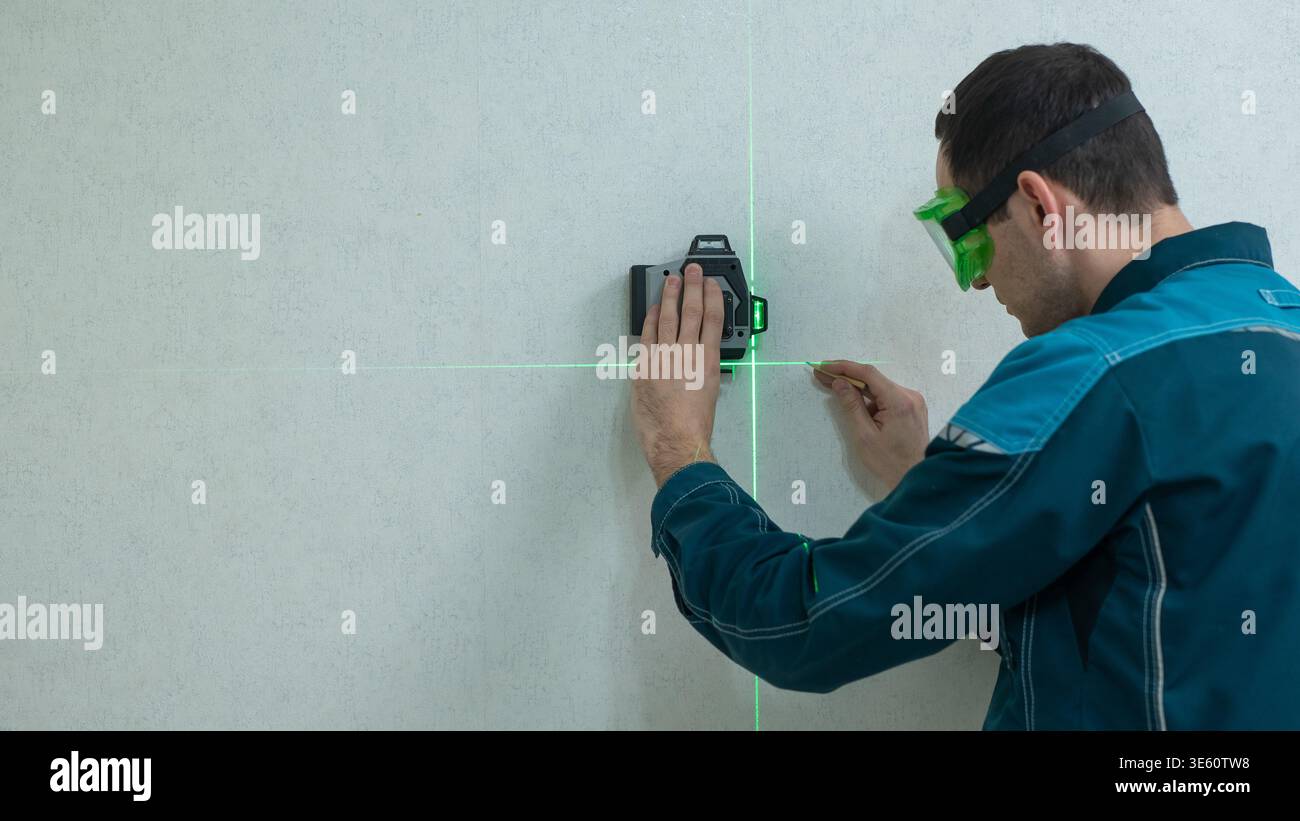 A man measures distance with a laser level.  Stock Photo
