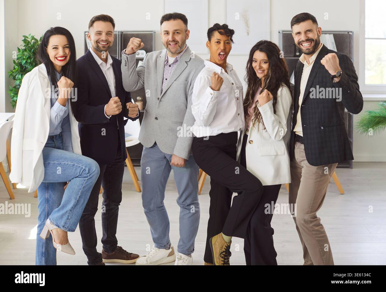 Six young multiethnic teammates celebrating joint success Stock Photo