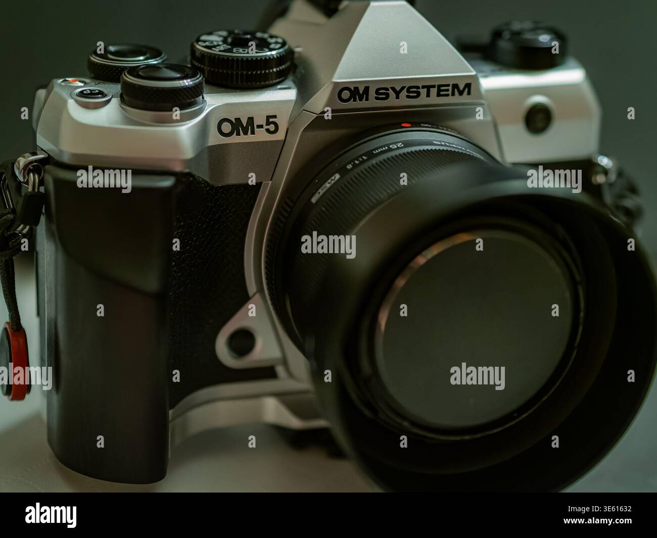 OM SYSTEM OM-5 silver mirrorless camera with lens and cap, close-up product photo Stock Photo