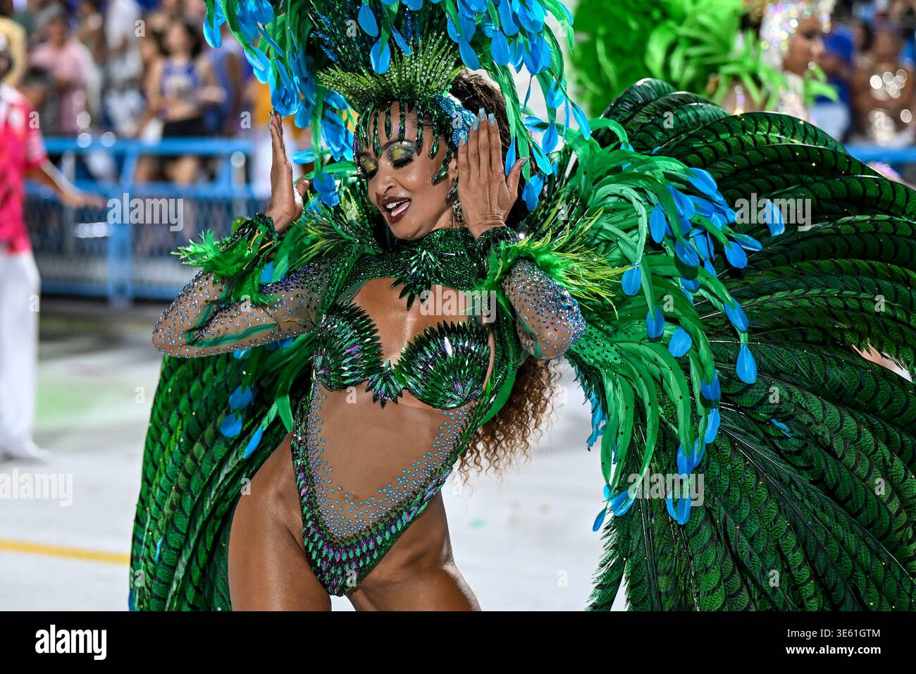 Rio de Janeiro, Brazil - February 15, 2026: Samba dancer in a green and blue jeweled costume performs with expressive movements during Estacao Primeir Stock Photo