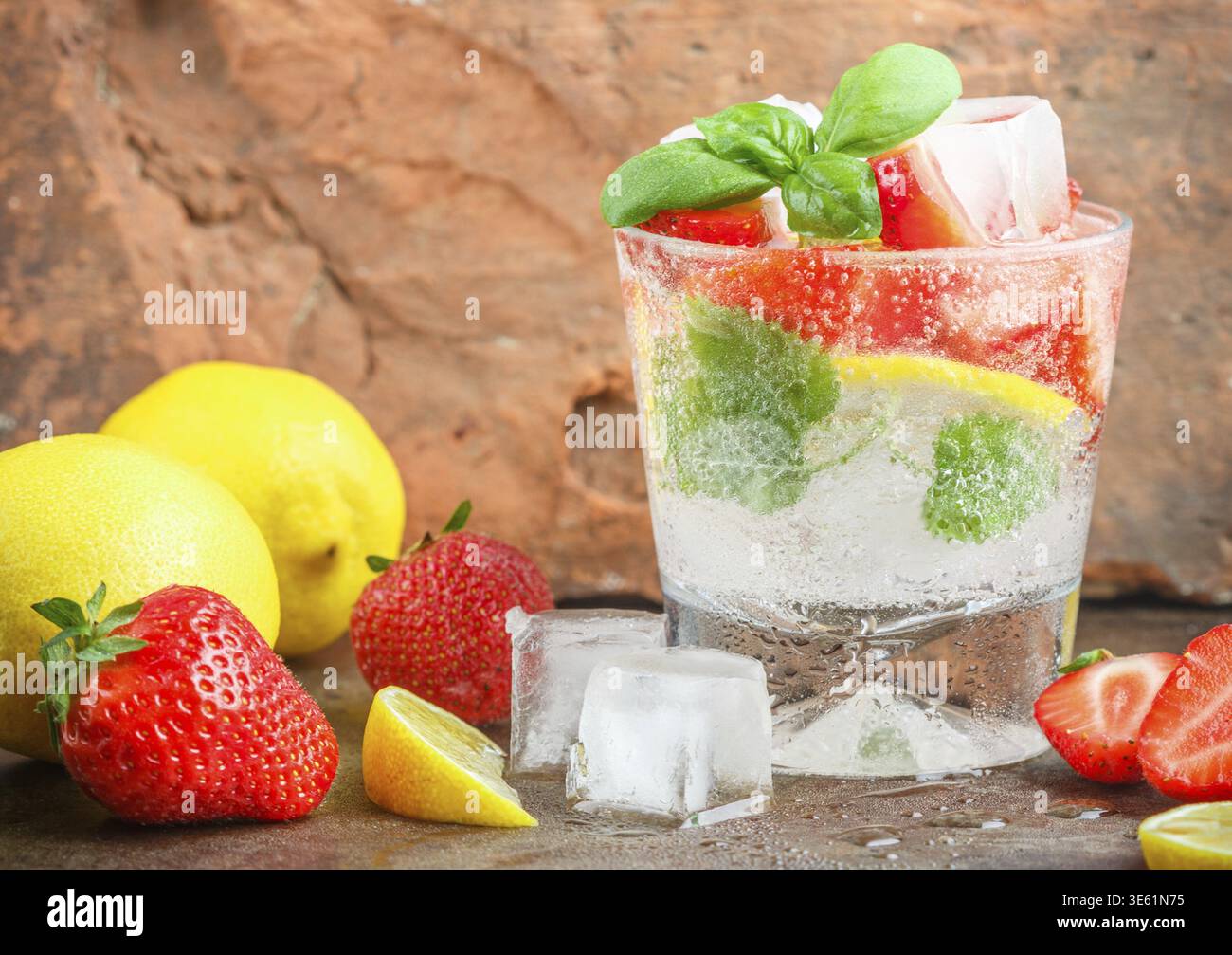 Sommerliche Erfrischung mit Limonade. Mit Zitrone, Erdbeeren, Minze, Basilikum und Eis servieren. Entgiften. Mineralwasser. Selektiver Fokus Stock Photo