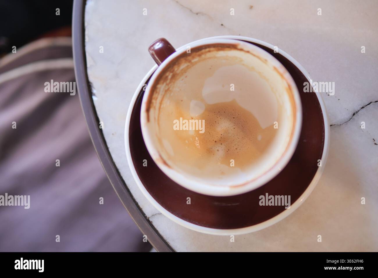 Coffee cup sits empty on a table after morning drink Stock Photo