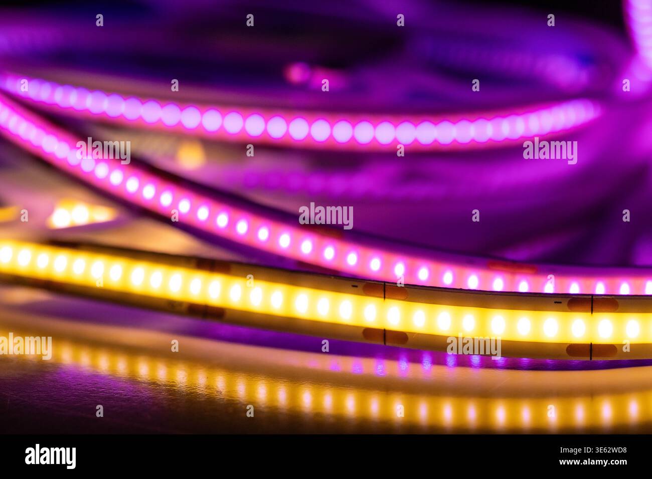 Colorful LED strip lights with reflections on dark surface Stock Photo