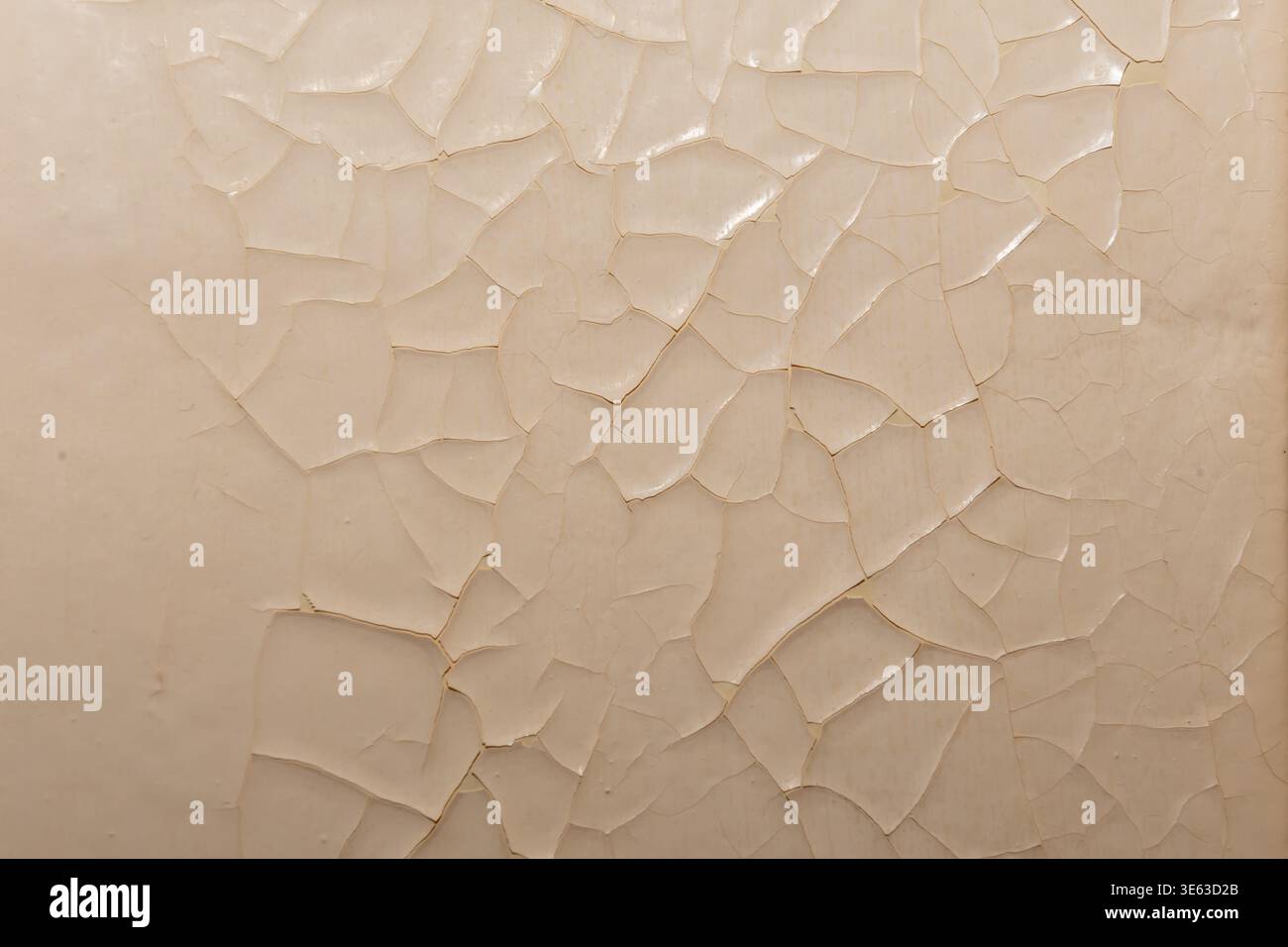 Old paint peeling on wall forming pattern of damaged surface material. Stock Photo