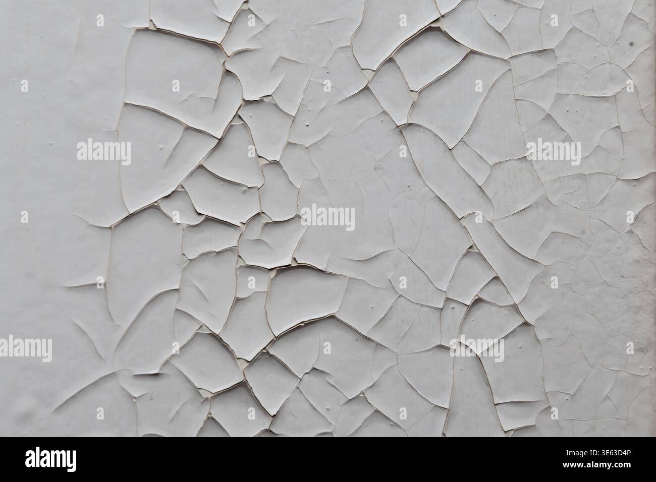 White paint on wall cracked creating contrast texture of aged surface. Stock Photo