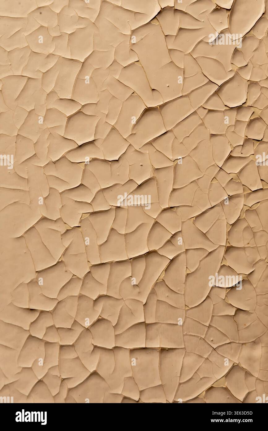 Peeling paint on wall creates pattern of worn surface and material defects. Stock Photo