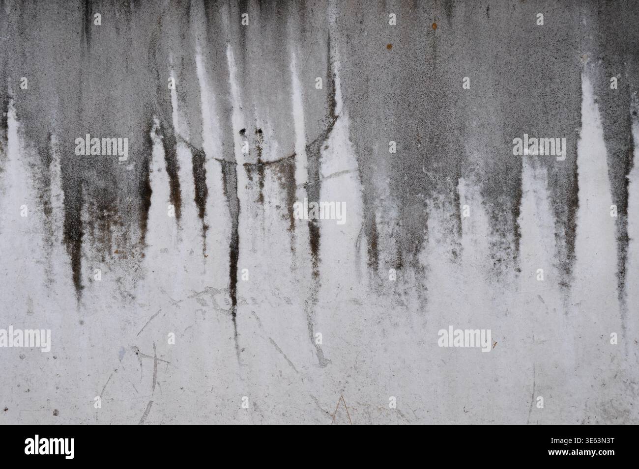 Grungy weathered concrete wall with dripped water, displaying vertical water stains and drip patterns Stock Photo