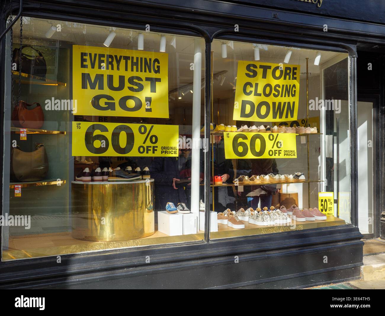 Store closing down and everything must go sale signs inside shoe shop window, London, UK Stock Photo