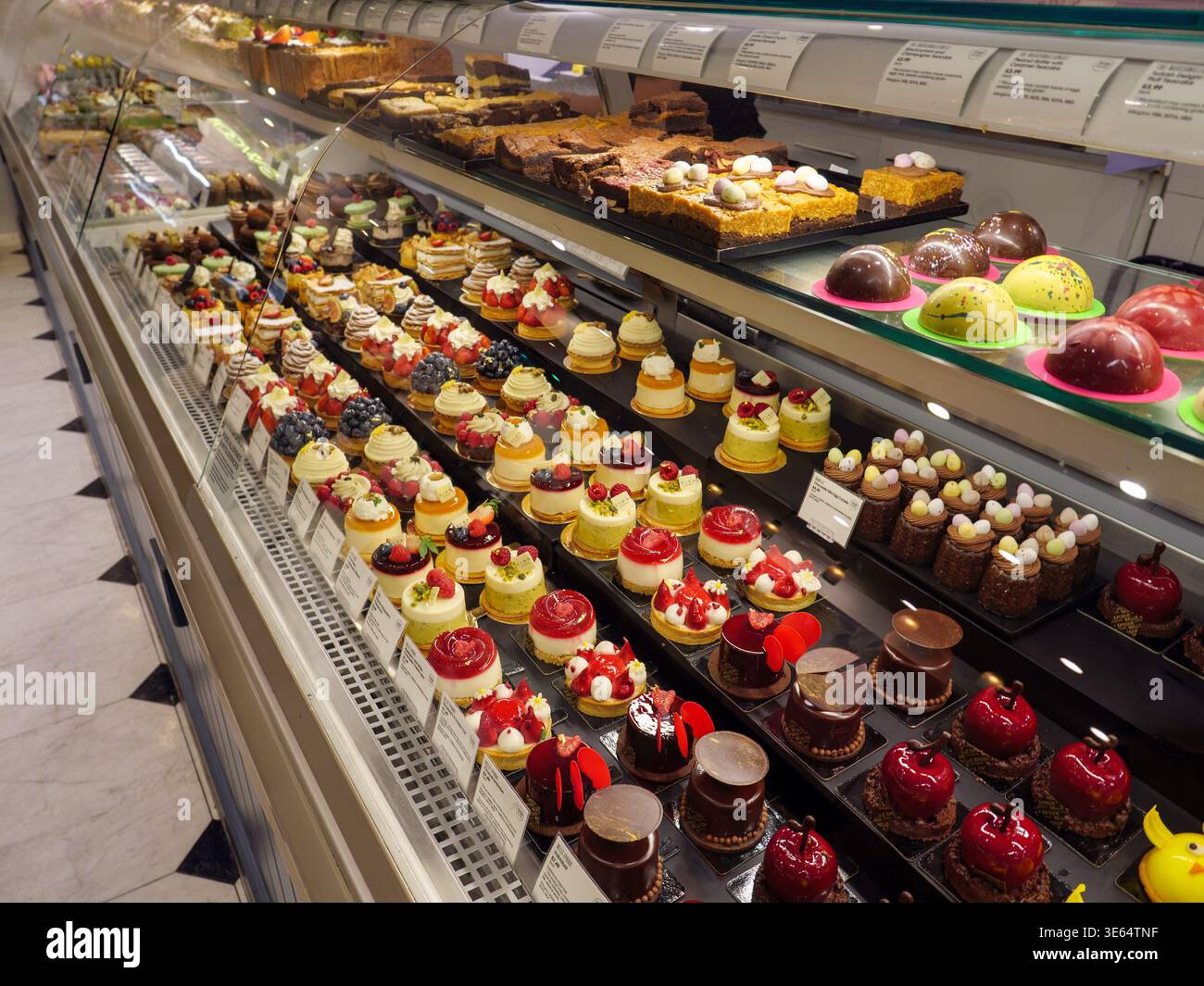Sweet cakes and deserts at the patisserie counter inside the Food Hall at Selfridges, London, UK Stock Photo
