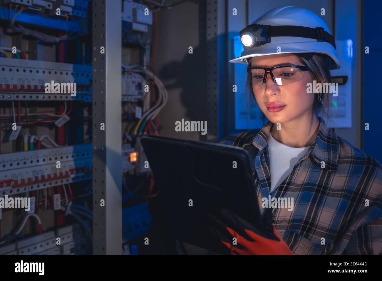 Electrical specialist inspecting power system with tablet. Engineering control. Stock Photo