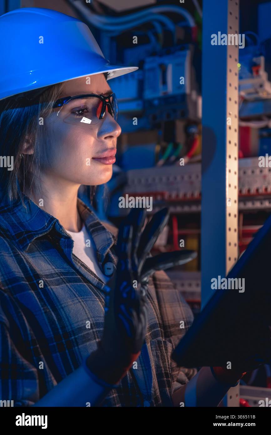 Electrical specialist working with tablet during system inspection. Engineering control. Stock Photo