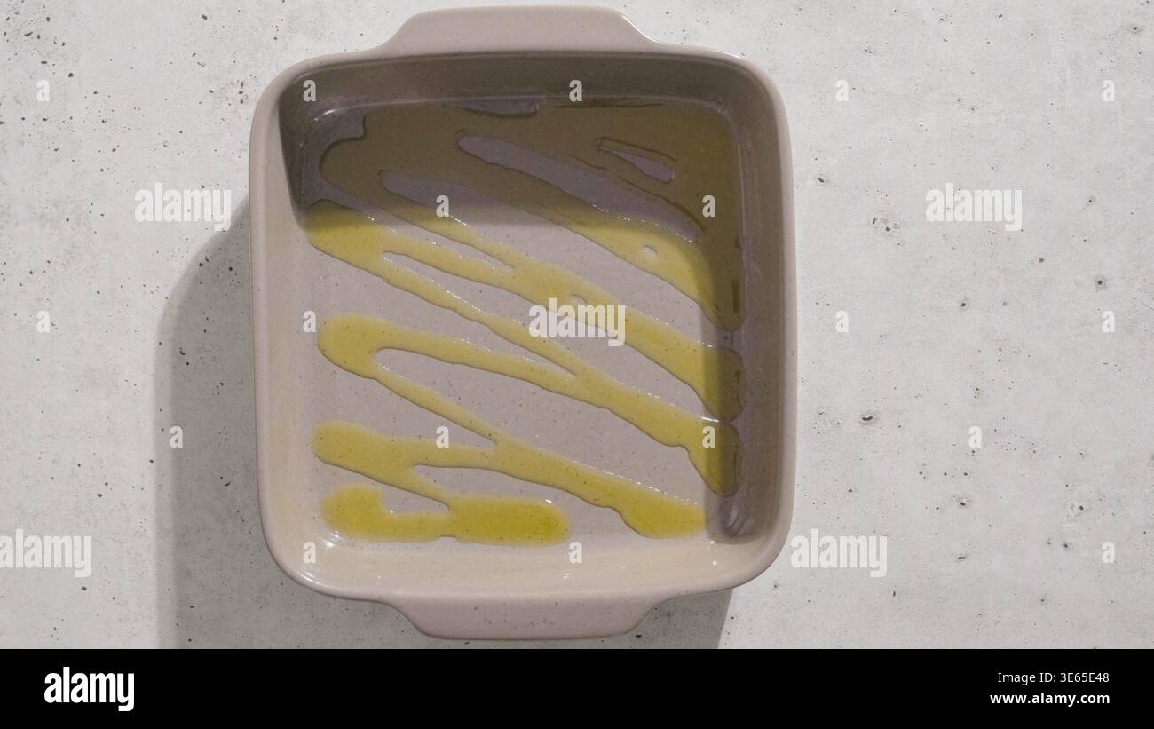 Drizzled oil inside empty ceramic baking dish preparation Stock Photo