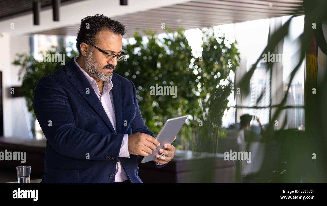 Focused executive reviewing data on digital tablet Stock Photo