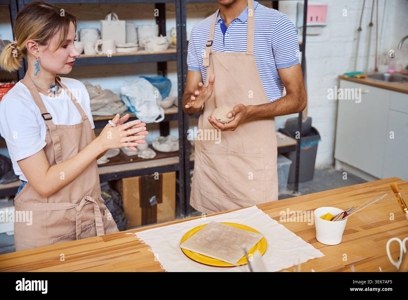 Young adults engaging in pottery at creative studio Stock Photo