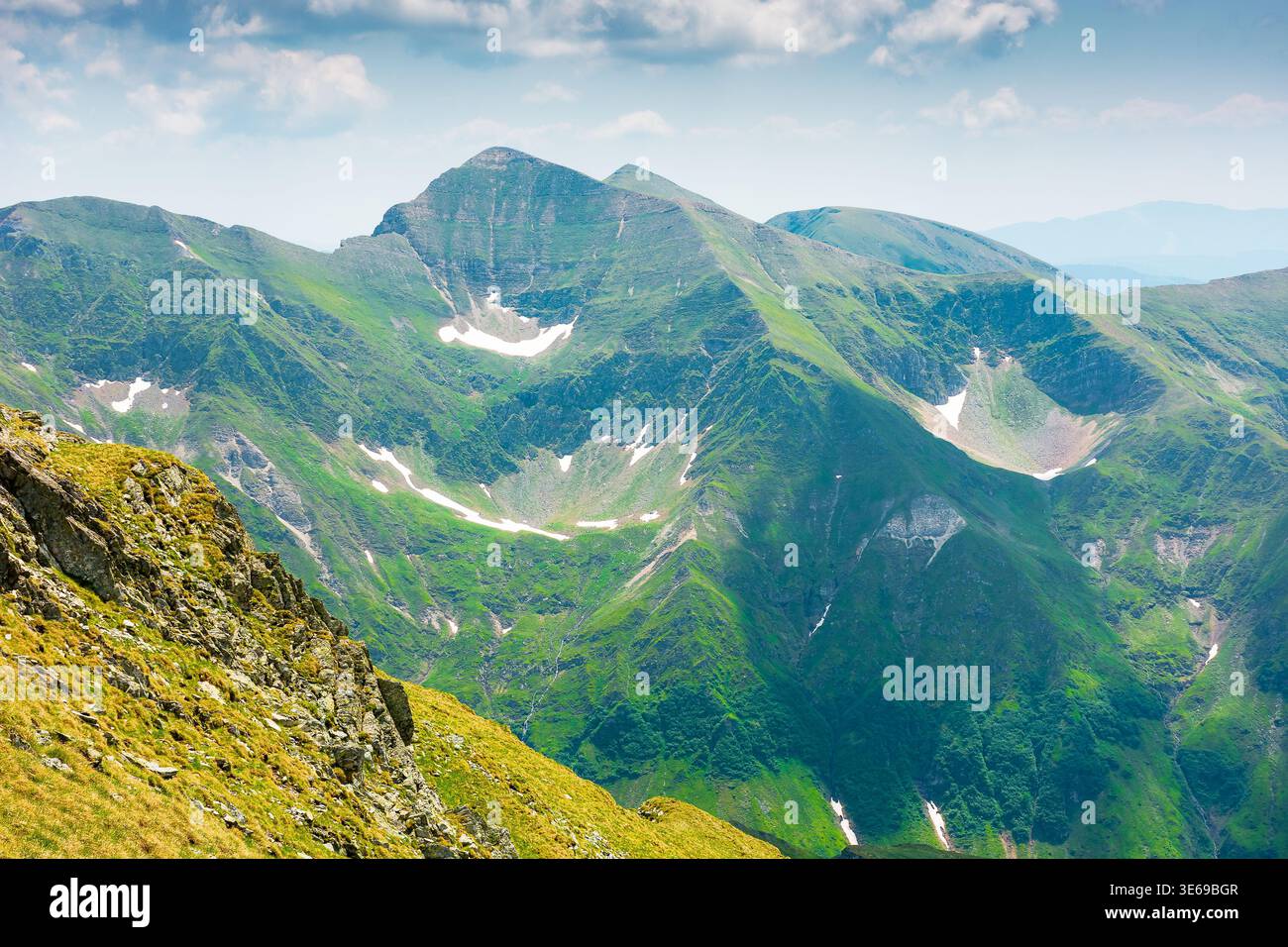 romania mountain scenery in summer. gorgeous mountainous landscape of carpathians. background with rocky cliffs and grassy hillsides under a cloudy sk Stock Photo