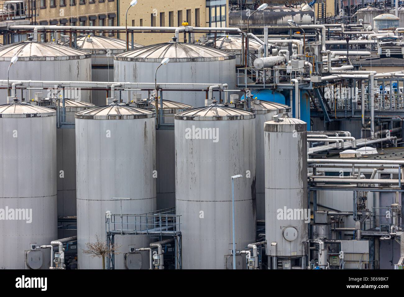 Large metal storage tanks holding chemicals and liquids at an ...
