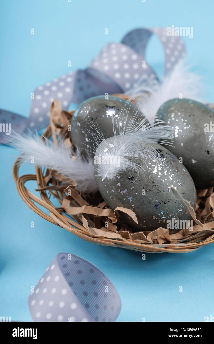 Easter eggs with white feathers in nest spring decoration Stock Photo