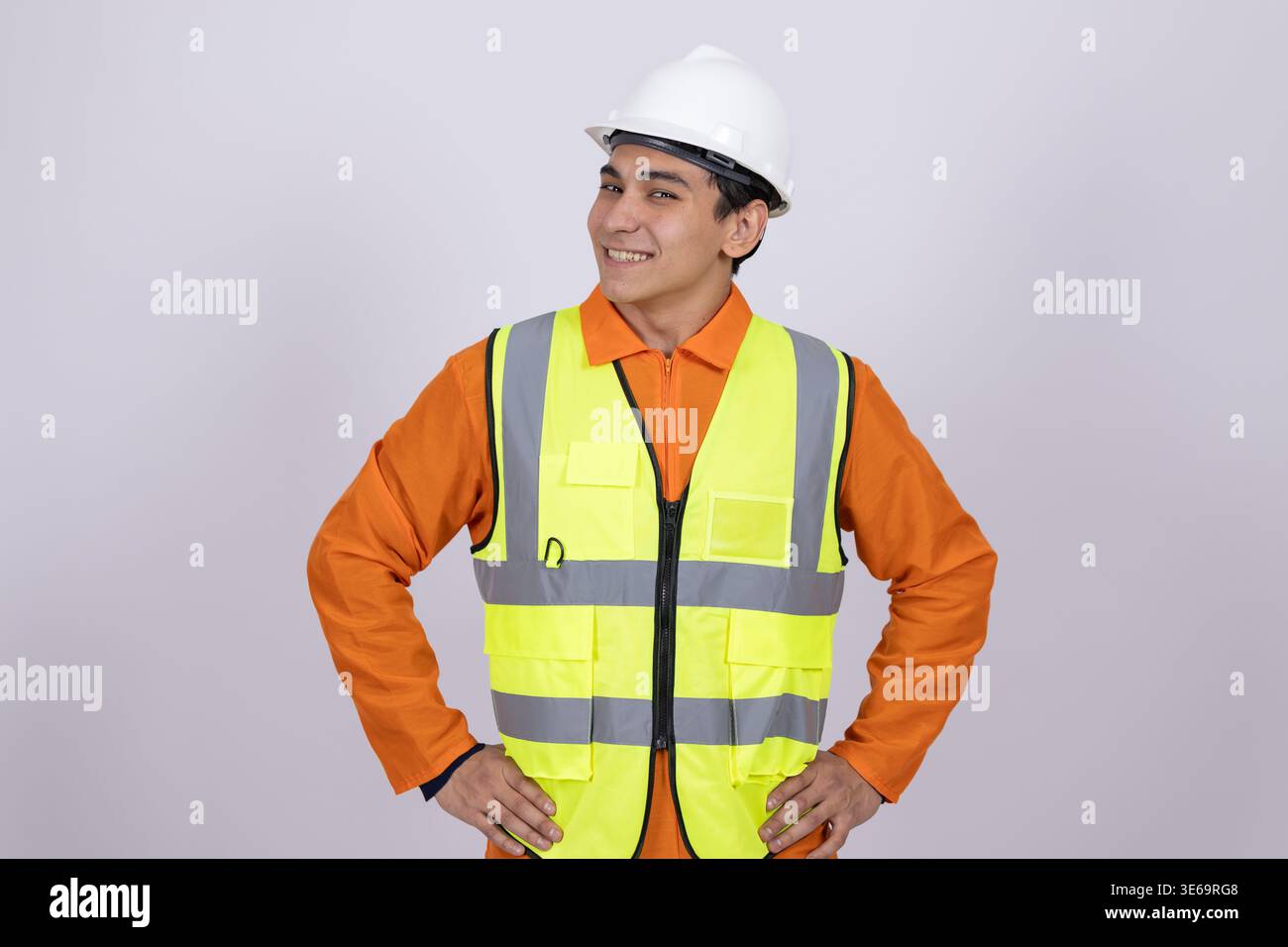 Professional builder in hard hat standing with hands on hips Stock Photo