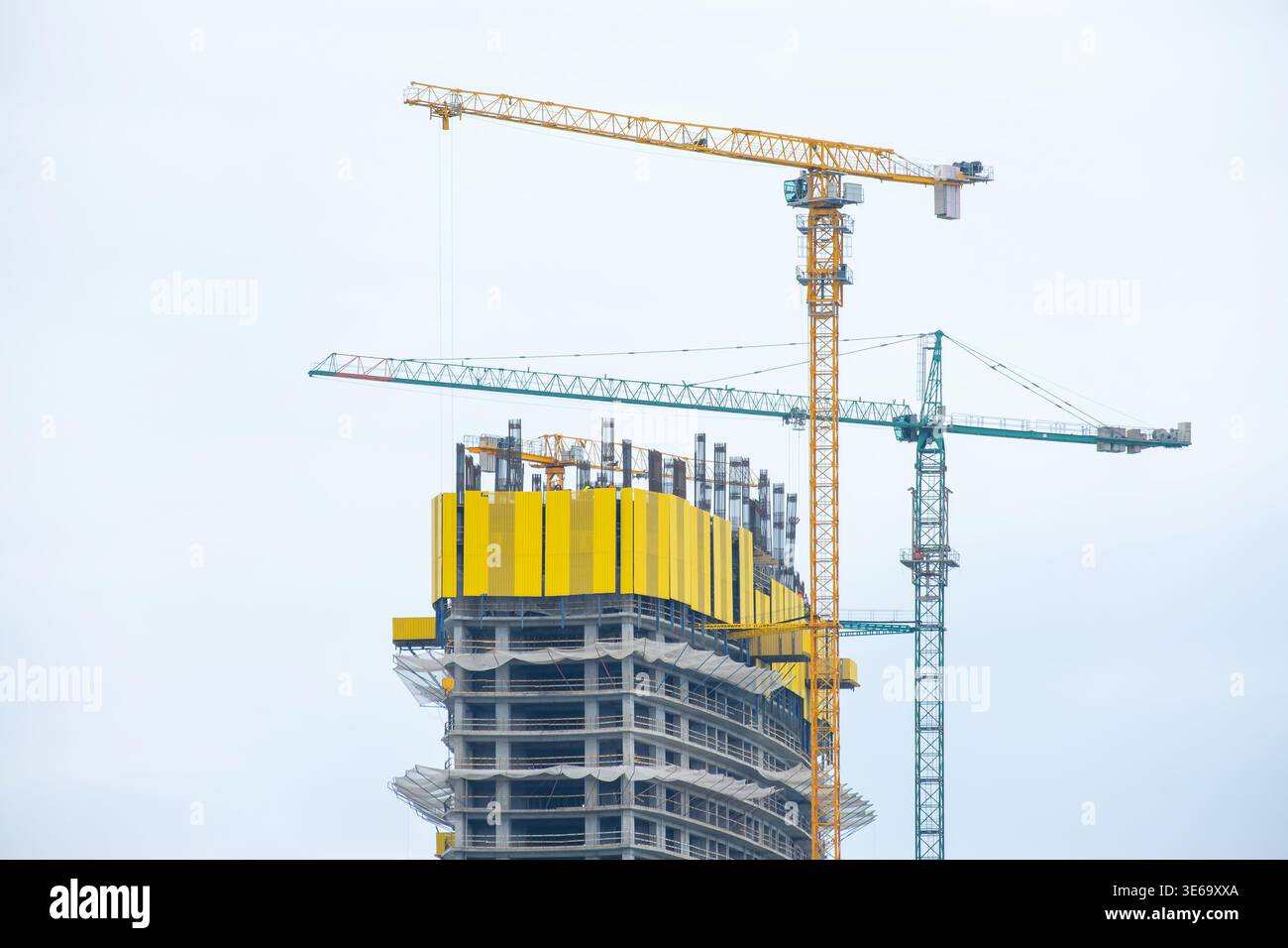High rise building under construction with tower cranes and structural ...