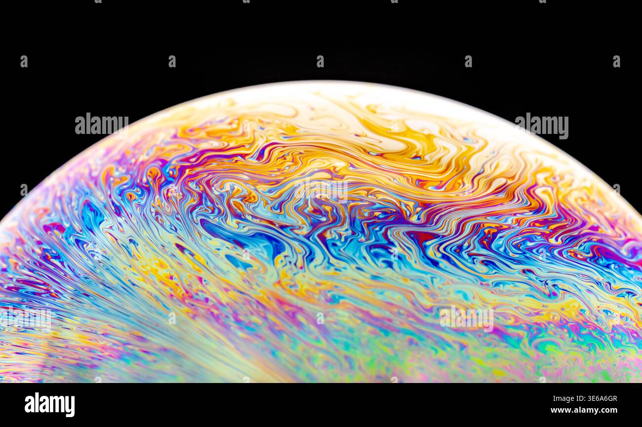 Macro photography captures the vibrant, swirling colors and fluid dynamics of a soap bubble's surface, creating an abstract visual spectacle Stock Photo