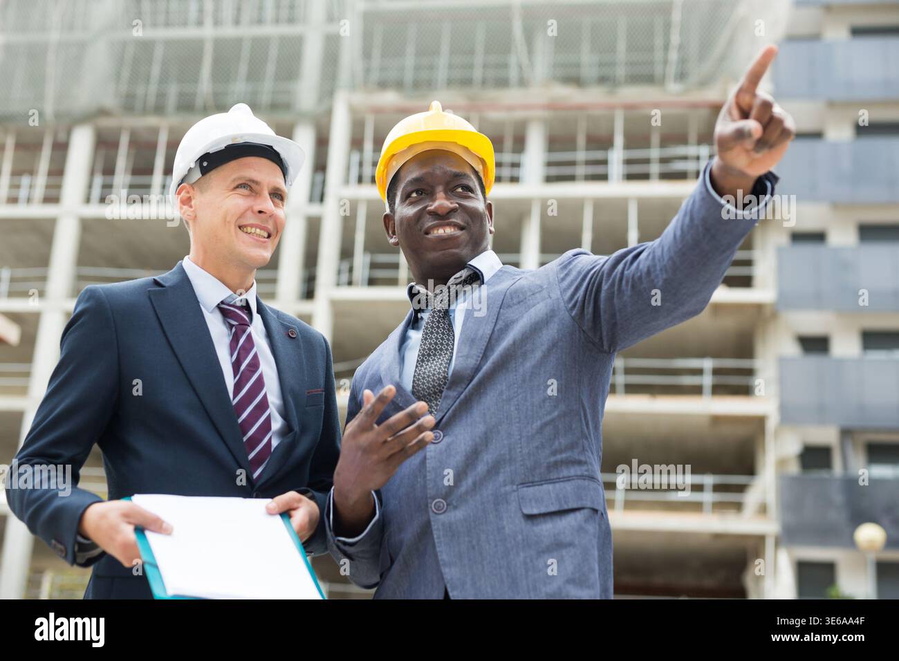 Architects talking about project documentation on construction plant Stock Photo