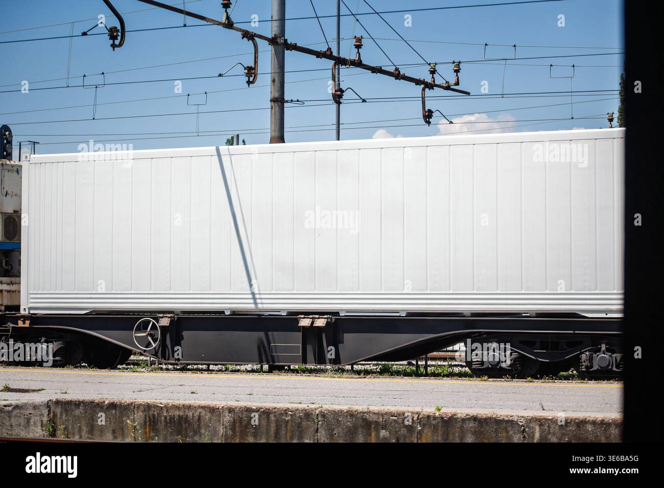 White Container Train White refrigerated container mounted on a rail wagon at a station yard ...