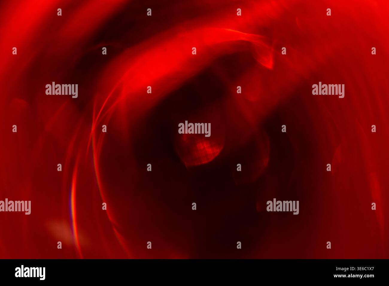 Abstract image featuring a swirling red pattern with blurred light reflections, ideal for use in artistic projects or as a background element Stock Photo