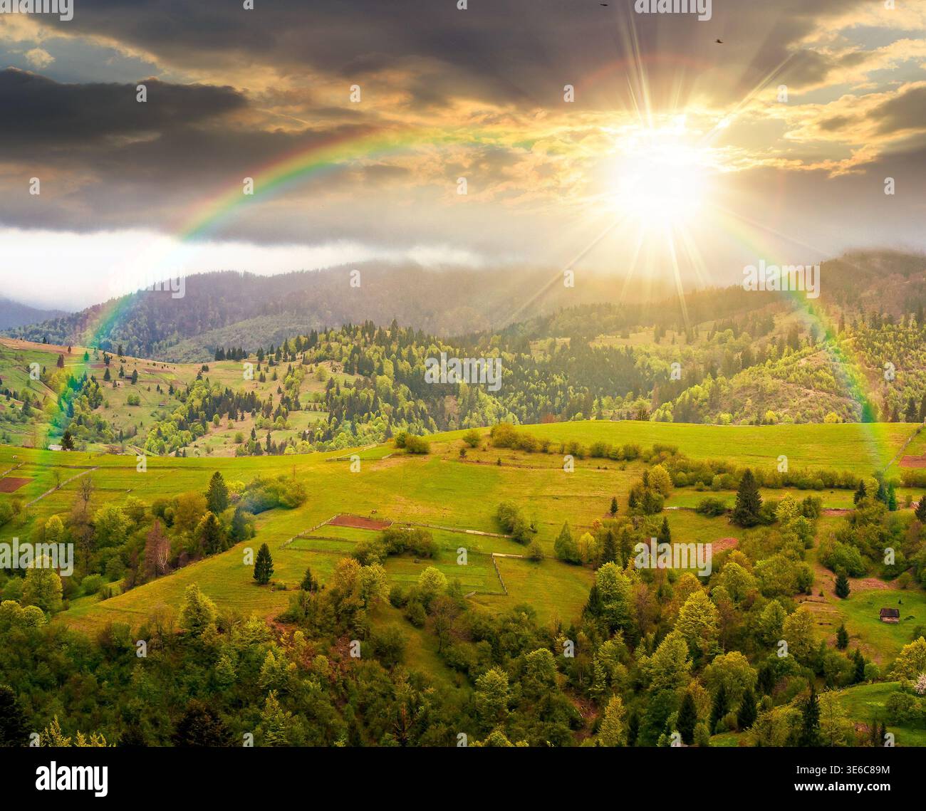 rural mountain landscape during spring at sunset. wonderful countryside scenery on a cold weather in evening light. cloudy sky above rolling hills in Stock Photo
