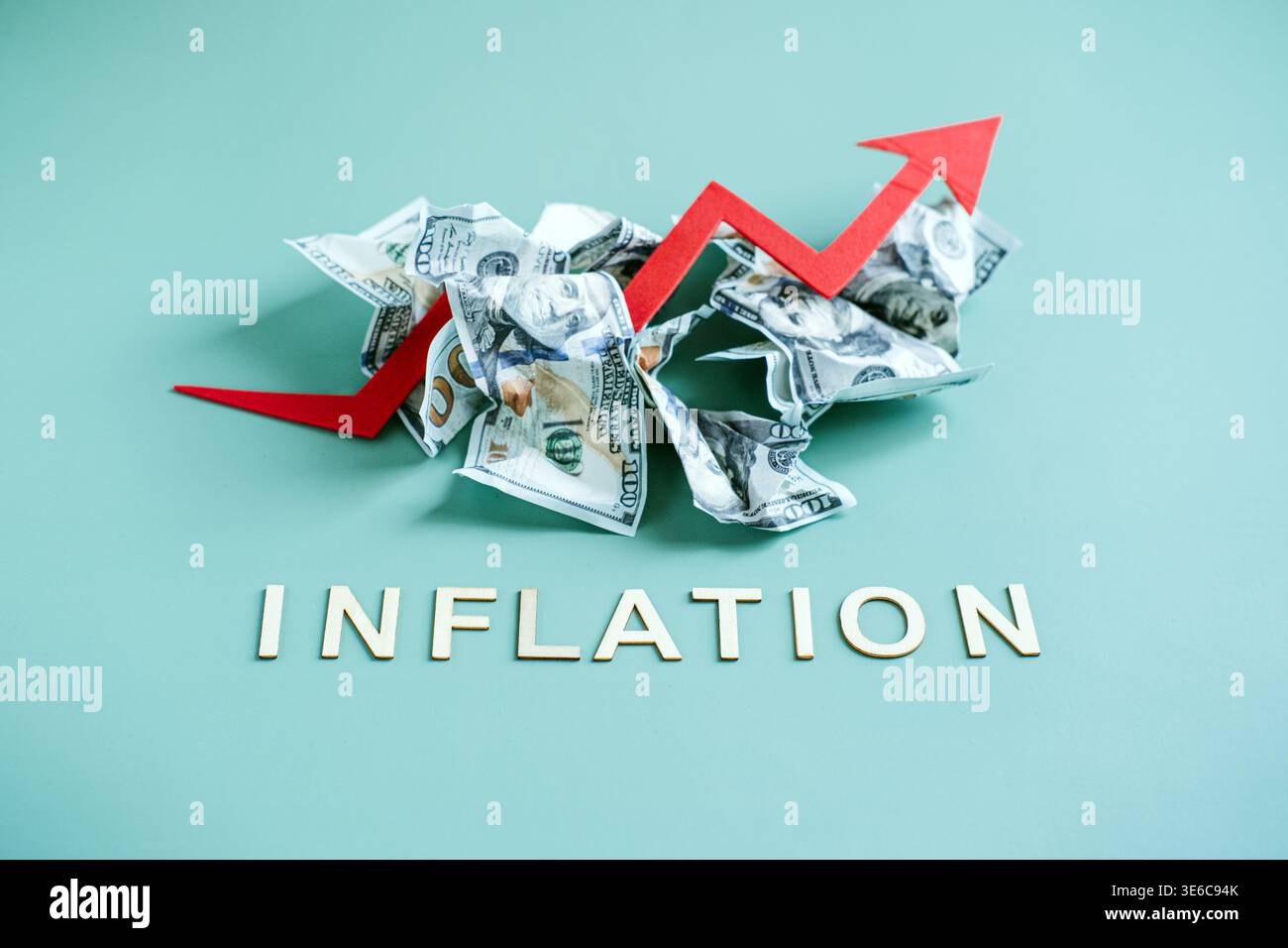 Arrow Rising Inflation Red arrow points upward over pile of crumpled hundred dollar bills ...