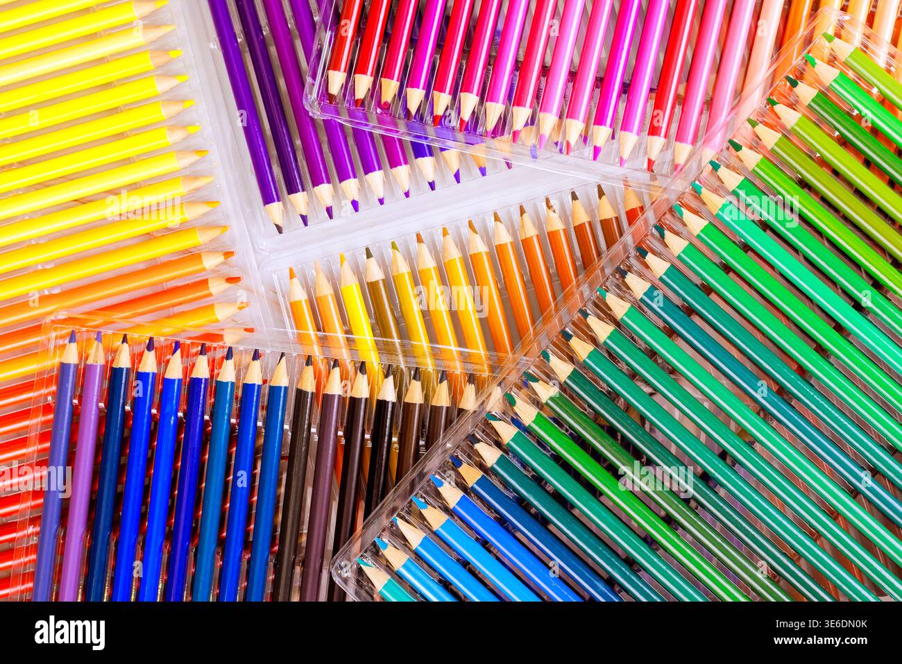 Different boxes hold many colored pencils on clean surface in creative area. Stock Photo