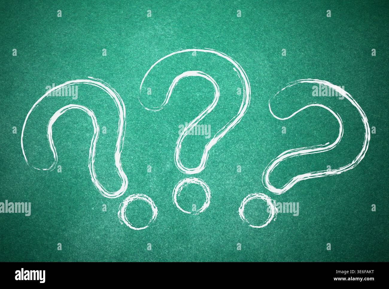 Three question marks drawn on green chalkboard Stock Photo