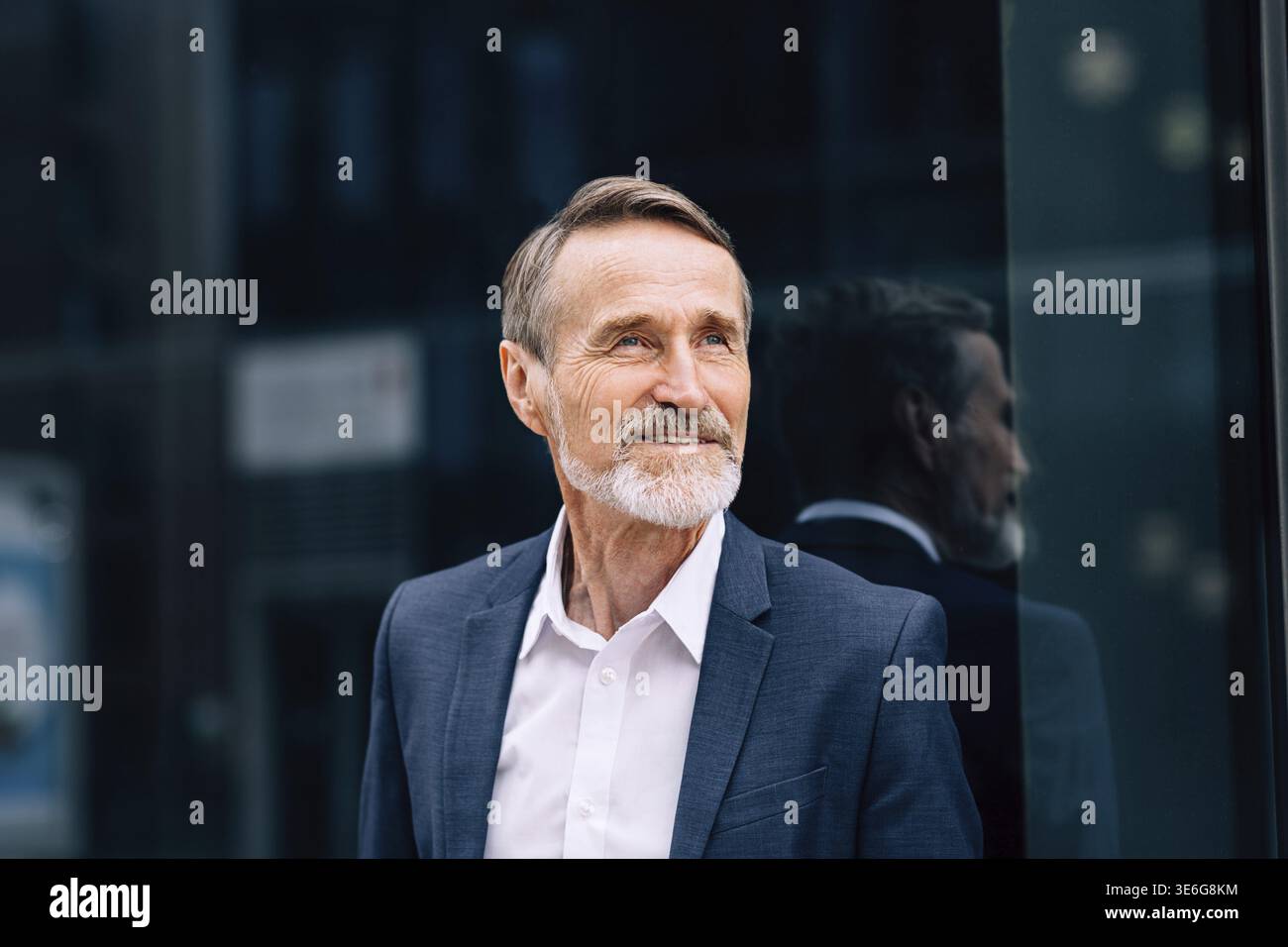 Bearded man wearing suit standing at office building outdoors Stock Photo