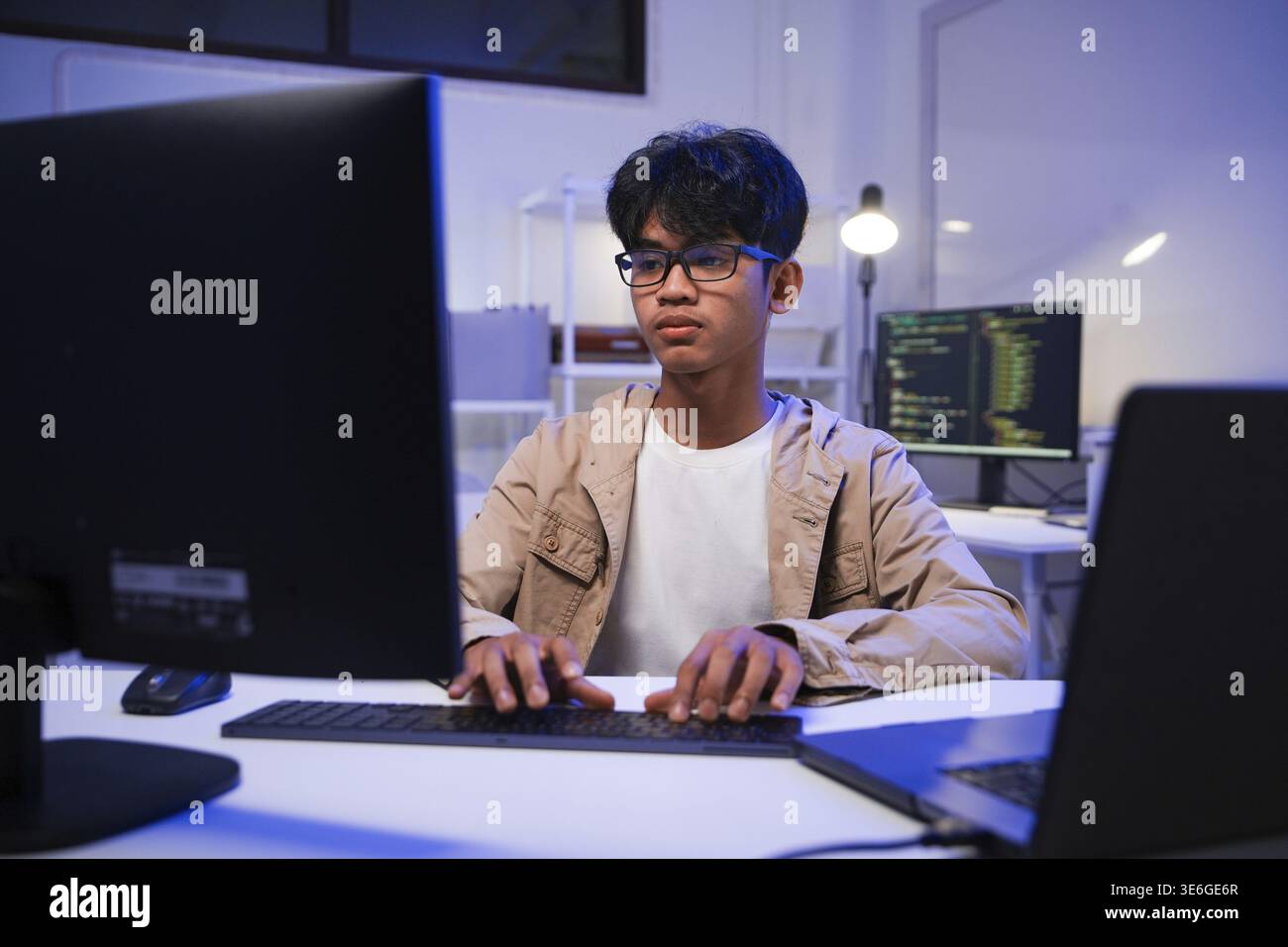 Male Software Engineer Writing Code on Desktop Computer with Multiple ...