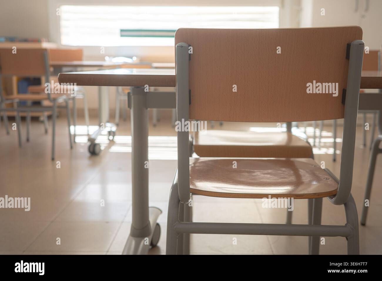 Empty classroom with desks and chairs in daylight Stock Photo
