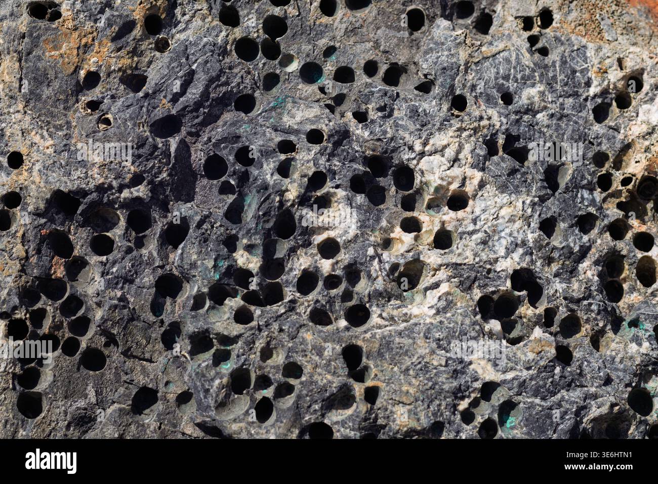 Basalt rock surface creating abstract pattern with dark hollows Stock Photo