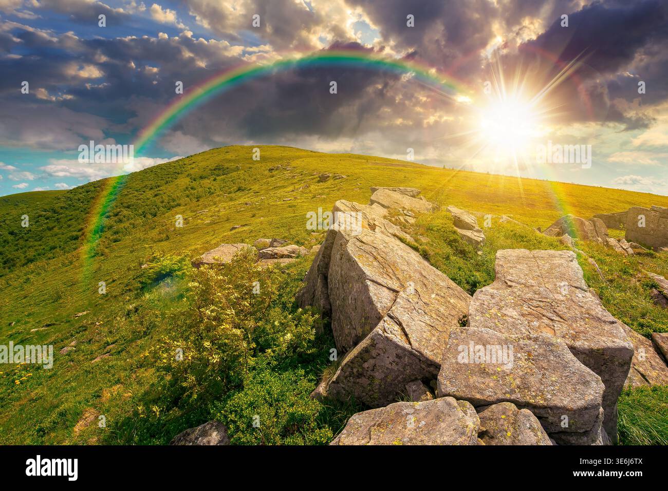 sunset over rocks and rolling hills in mountain landscape in summer. scenery with green grass on alpine meadow under sky with clouds. background for r Stock Photo