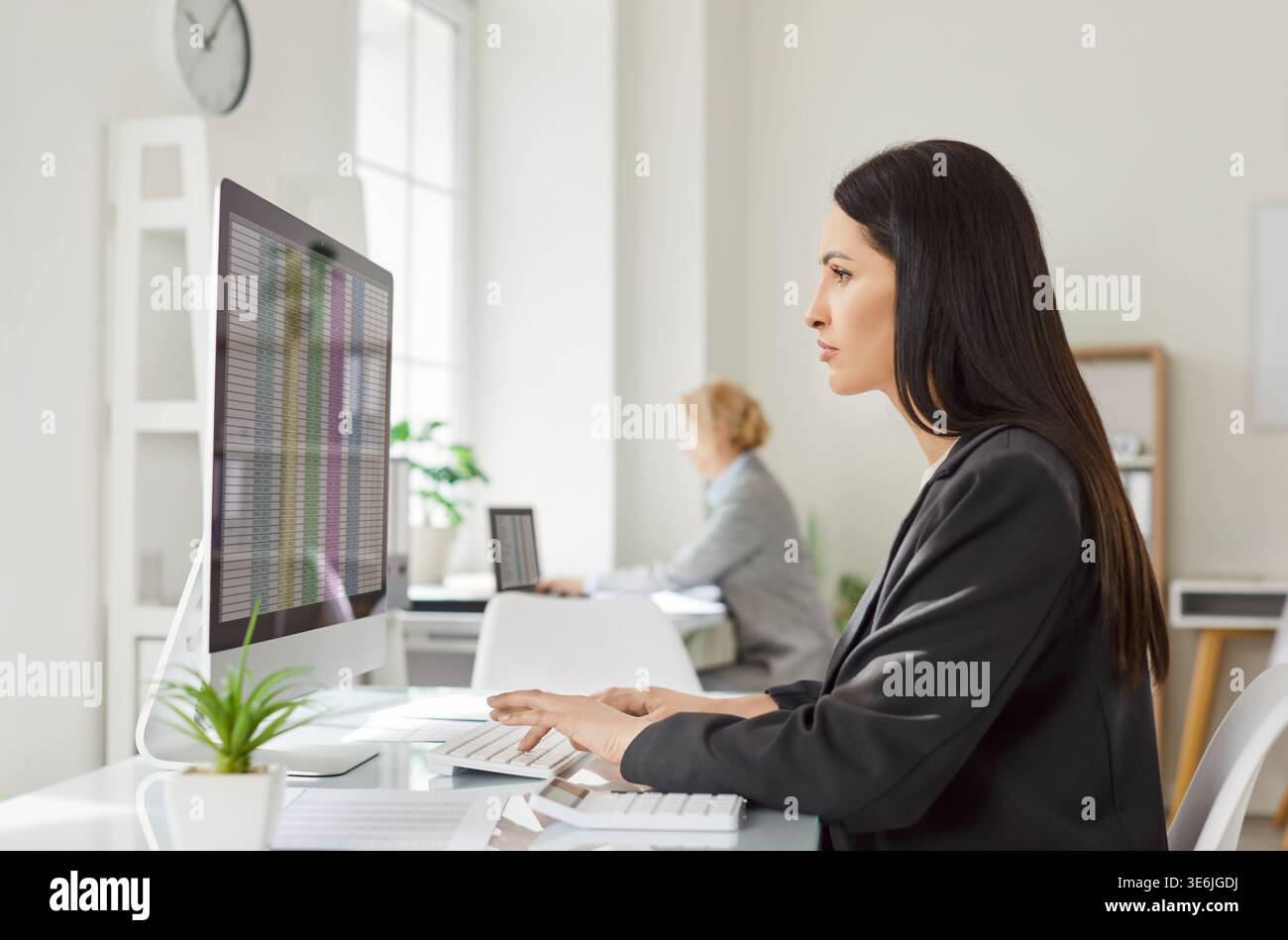 Serious brunette woman concentrated in screen of computer, checking ...