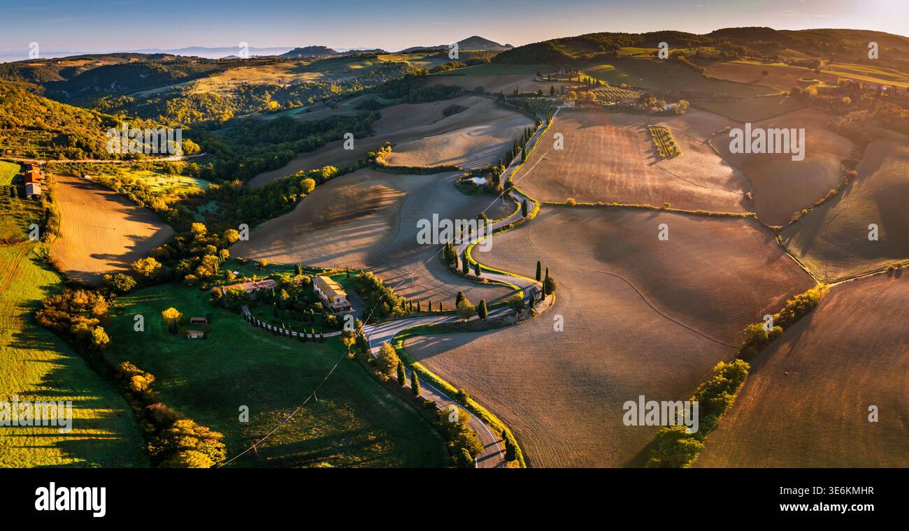 Aerial view of a scenic winding road lined with cypress trees ...