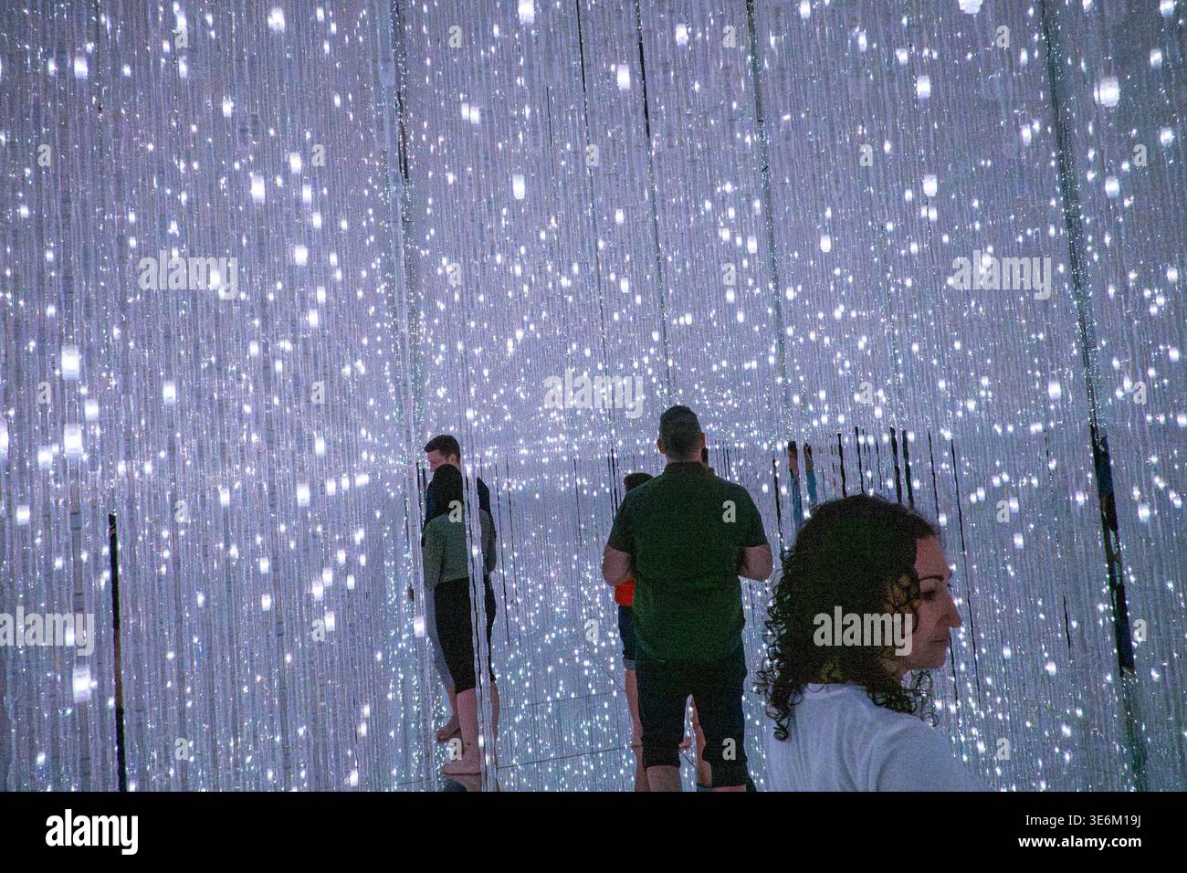 Teamlab Lighting A visitor walks through cascading LED light strands inside an immersive ...