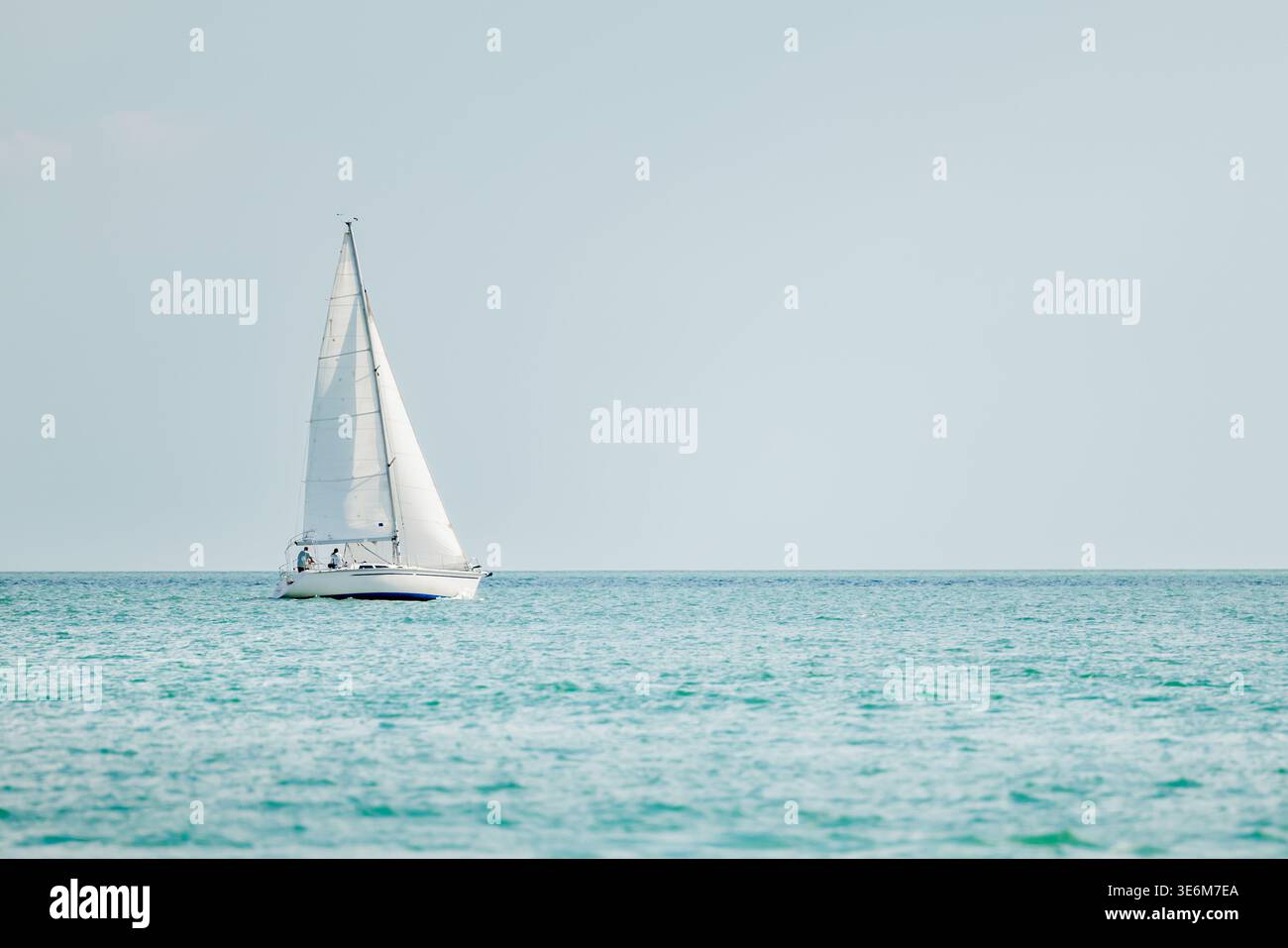 Sailboat on a sunny summer day. Couple on sailing vessel cruising the blue water of the Gulf of America, Florida. Stock Photo